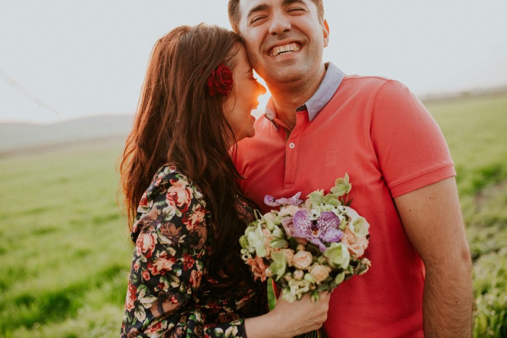 Hombre y mujer sonrientes con un ramillete de flores